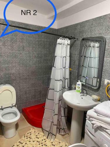 a bathroom with a white toilet and a sink at Traditional Bazaar Home2 in Korçë
