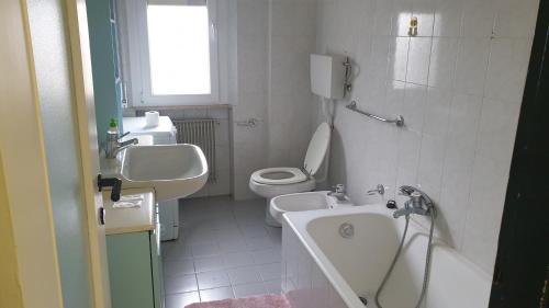 y baño con aseo, lavabo y bañera. en Appartamento vicino università, en Piacenza