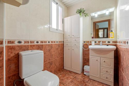 クニットにあるApt en Cunit con piscina compartidaのバスルーム(トイレ、洗面台、鏡付)