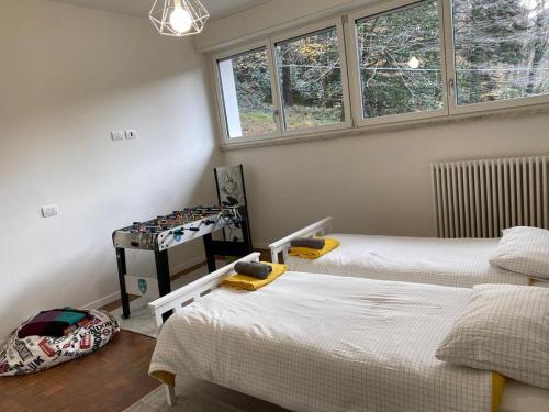 two beds in a room with two windows at SleepWell in Valganna in Valganna