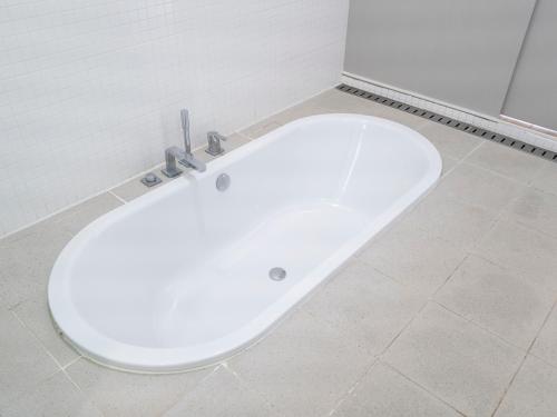 a white bath tub sitting in a bathroom at Boutique Pool Villa NAMIB in Jeju