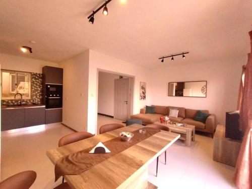 a living room with a wooden table and a couch at Unique Mellieha views, Sea Breeze in Mellieħa