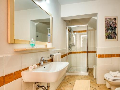bagno con lavandino, servizi igienici e specchio di Golf Residenza a Peschiera del Garda