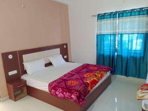 a bedroom with a large bed with blue curtains at YESH PALACE HOMESTAY in Khajurāho