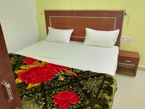a bedroom with a large white bed with flowers on it at YESH PALACE HOMESTAY in Khajurāho