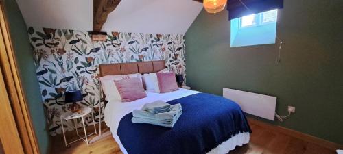 um quarto com uma cama com lençóis azuis e almofadas cor-de-rosa em Wilde Rooms em Weston