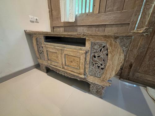 a wooden cabinet in the corner of a room at Royen Balinese Family Guest House- Traditional Batuan Homestay in Sukawati