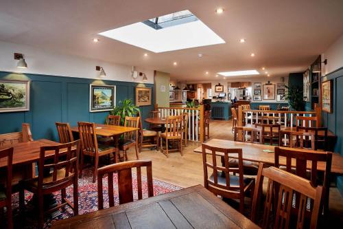 un restaurante con mesas de madera y sillas de madera en The Glengower, en Aberystwyth