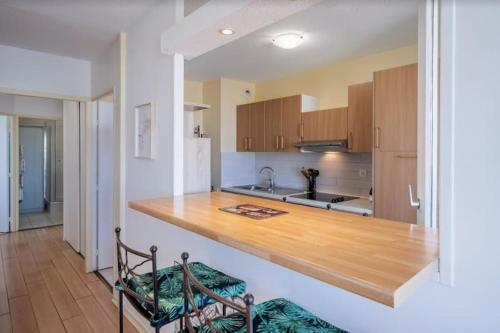 une cuisine avec un comptoir en bois dans une pièce dans l'établissement L'Horizon, T3, Terrasse, Pkg, Quartier Antigone, à Montpellier