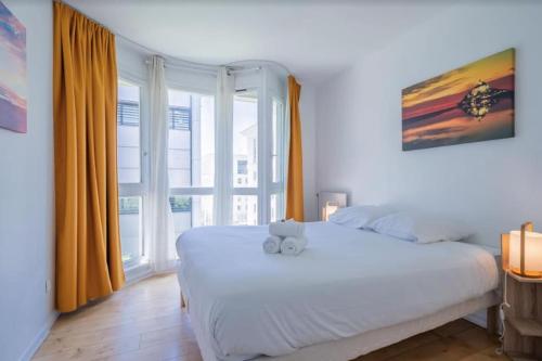 ein Schlafzimmer mit einem weißen Bett und einem großen Fenster in der Unterkunft L'Horizon, T3, Terrasse, Pkg, Quartier Antigone in Montpellier