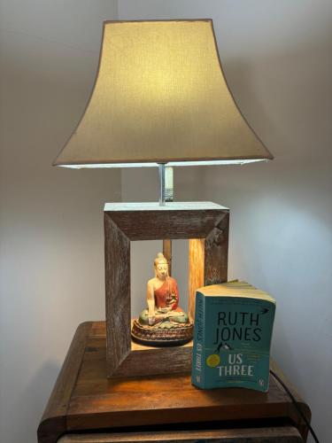 a lamp on a table next to a book at Royen Balinese Family Guest House- Traditional Batuan Homestay in Sukawati