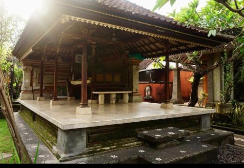 a small house with a bench in front of it at Royen Balinese Family Guest House- Traditional Batuan Homestay in Sukawati