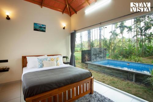 a bedroom with a bed and a swimming pool at StayVista at Palm Tree Homes with Complimentary Breakfast, BBQ Grill and Pet-Friendly Home in Wayanad