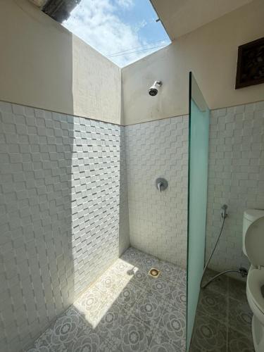 a bathroom with a shower with a skylight at Royen Balinese Family Guest House- Traditional Batuan Homestay in Sukawati