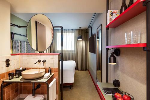 uma casa de banho com um lavatório e um espelho em me and all hotel Berlin east side, part of JdV by Hyatt em Berlim