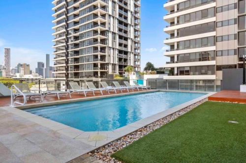 - une piscine avec des chaises longues au-dessus d'un bâtiment dans l'établissement Cozy 2 bed Retreat Milton - Pool, Walk to SStadium, à Brisbane