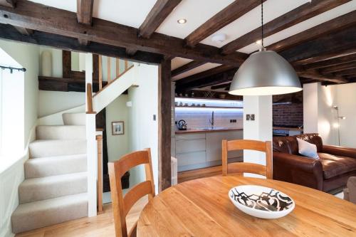 a dining room with a wooden table and a staircase at 2 Lower Raven Lane, Ludlow in Ludlow