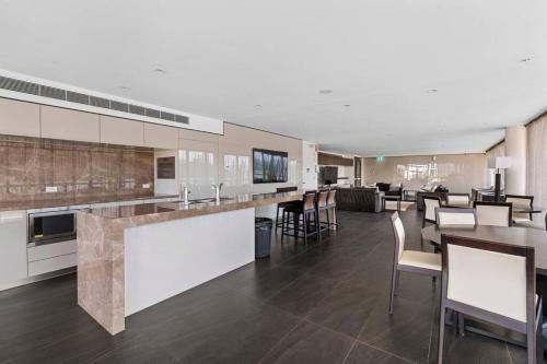 a large kitchen with tables and chairs in a building at Cozy 2 bed Retreat Milton - Pool, Walk to SStadium in Brisbane
