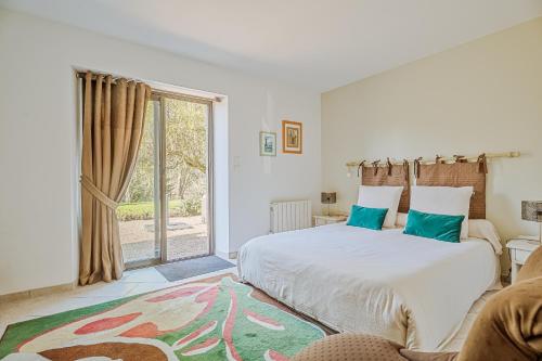 ein Schlafzimmer mit einem Bett und einem großen Fenster in der Unterkunft Chambre d'hôte La Chapelle in La Rochelle-Normande