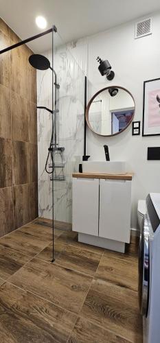 a bathroom with a shower and a sink and a mirror at Home Factory Ghandiego in Łódź