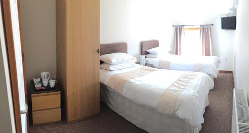 a hotel room with two beds and a window at The Nags Head Tredegar in Nant-y-bwch