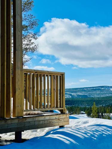 a wooden deck with snow on the ground at The Riverside Mountain Lodge - 110sqm clam luxury - including bed linens, towels, in Idre