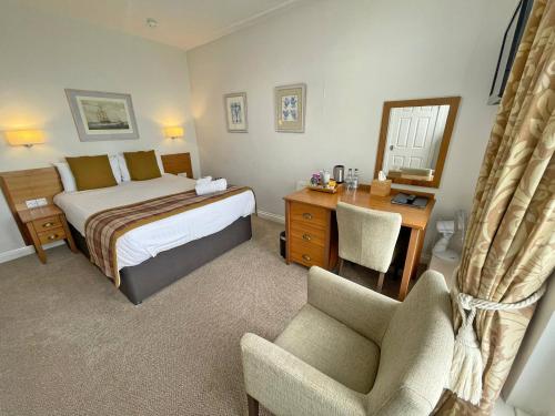 a bedroom with a bed and a desk and a chair at The Glengower in Aberystwyth