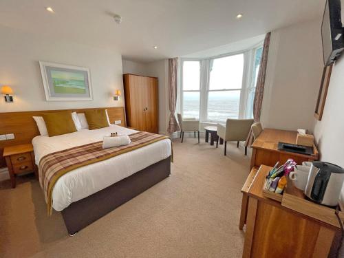 a hotel room with a bed and a desk and a room at The Glengower in Aberystwyth