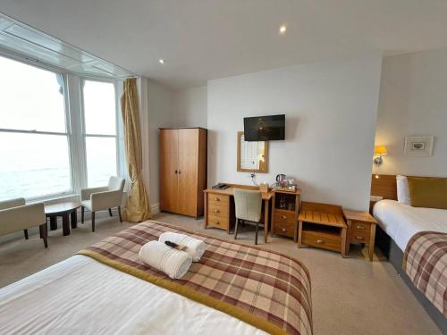 a hotel room with two beds and a desk at The Glengower in Aberystwyth
