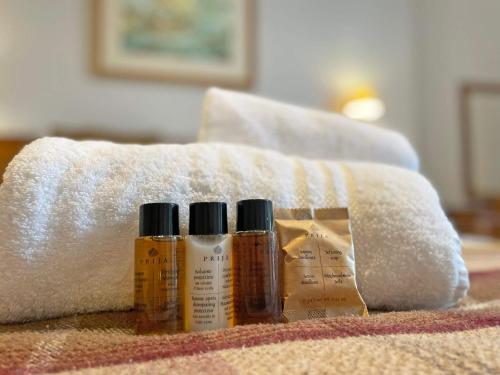 three bottles of moisturizers sitting next to a towel at The Glengower in Aberystwyth