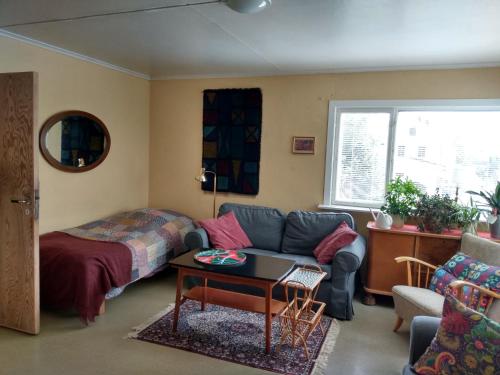 a living room with a couch and a bed at 1940s house in Vestre Toten in Boverbru