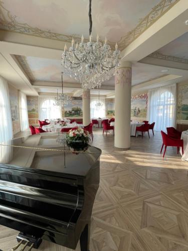 a piano in a room with tables and chairs at Accomodation Hotel Castello Il Codirosso in Cesate