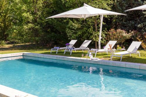 a group of chairs and an umbrella next to a pool at La Bastide de Damien, 5 clefs Demeure d'Exception et Table Remarquable dans le guide Teritoria, JACUZZI Privatif, Cuisine étoilée Dominique Frérard in Aix-en-Provence