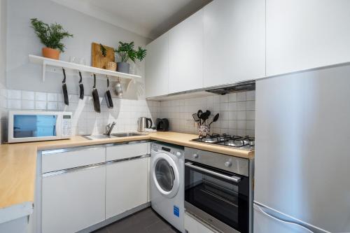 ロンドンにあるFulham Road Apartmentsのキッチン(洗濯機、乾燥機付)