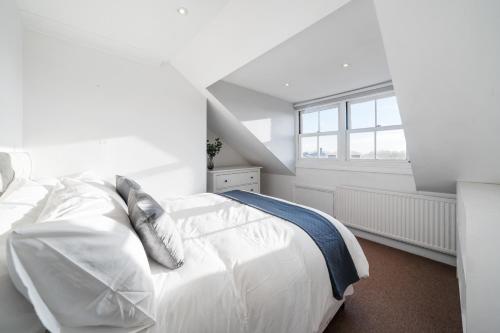 ロンドンにあるFulham Road Apartmentsの白いベッドルーム(白いベッド1台、窓付)