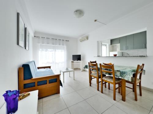 a kitchen and dining room with a table and chairs at Squash Club Apartamentos in Portimão