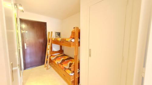 Cette chambre dispose de lits superposés et d'une porte. dans l'établissement Gioberney - 17 - Studio bord de piste - 4 pers, à Les Deux Alpes