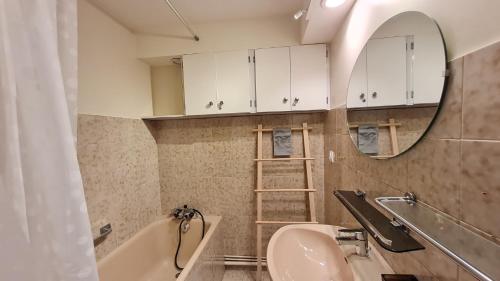 une salle de bain avec une baignoire, un lavabo et un miroir dans l'établissement Gioberney - 17 - Studio bord de piste - 4 pers, à Les Deux Alpes