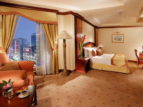 a hotel room with a bed and a large window at Knight Castle Hotel - Formerly known as Carlton Palace Hotel in Dubai