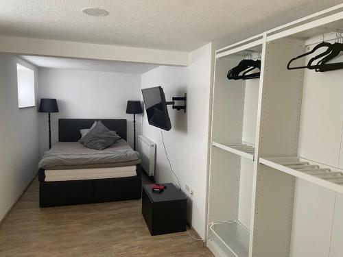 a small bedroom with a bed and a closet at BayrischGut Ferienwohnung in Orschweier