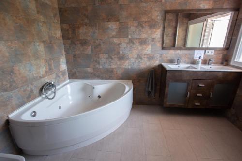 uma casa de banho com uma grande banheira branca e um lavatório. em BBTK Eco-Hostel em Málaga