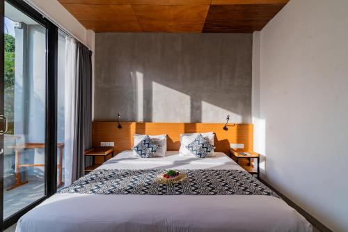 a bedroom with a bed with a bowl of fruit on it at The Nani in Ubud