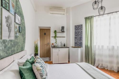 Un dormitorio con una cama blanca y una cocina. en Nightfall Escape - M&N Condos, en Bucarest