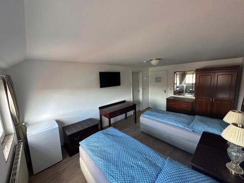 a hotel room with two beds and a desk at Gästehaus am Harz in Goslar