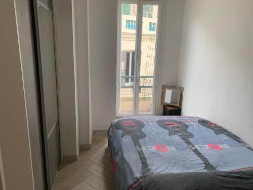 une chambre avec un lit dans une pièce avec une fenêtre dans l'établissement Charmant Appartement à 5 minutes de la plage, à Nice