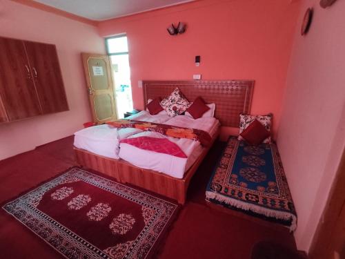 una camera da letto con pareti rosse e un letto con due tappeti di Dream villa a Leh