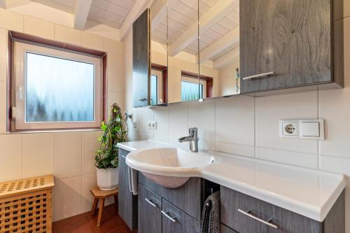 een badkamer met een wastafel en een raam bij Ferienwohnung Sonnenschein in Baiersbronn