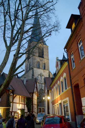 a church with a steeple in a town with buildings at Apartment Am Stadtwald in Werne an der Lippe / NRW in Werne an der Lippe
