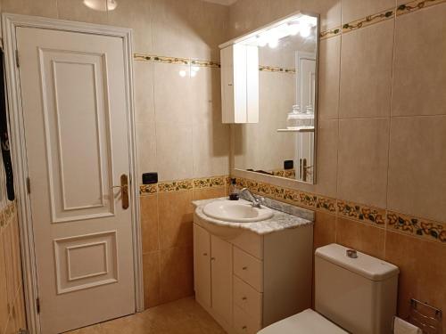 een badkamer met een wastafel, een toilet en een spiegel bij Rincón de Joel Habitación con baño privado in La Orotava