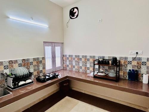 a kitchen with a counter and a clock on the wall at Gooseberry Garden in Ayodhya